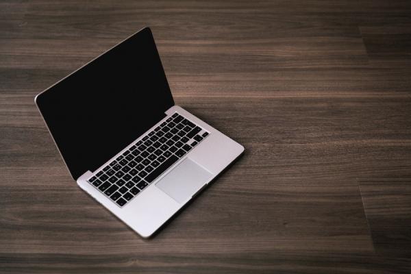 Laptop on dark wooden table.